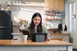 © PRIME STOCK LAB - Young asian woman happily working on laptop in modern home office. The space is well-lit and features stylish decor, creating a productive atmosphere.