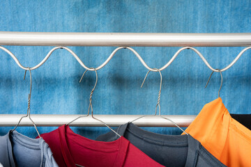 Colorful Dresses Hanging on Hangers on the Clothesline with Blue Towel Background