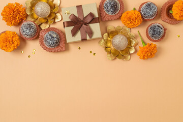 Diwali holiday concept with sweet traditional dessert, gift box and decorations on modern background. Top view, flat lay