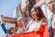 © Odua Images - A diverse group of activists raising their fists and colorful banners during a protest