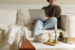 © RooM The Agency - Young woman sitting on a comfortable sofa in her living room using her laptop computer