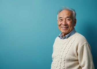 elderly asian man smiling happily in casual attire against turquoise background with copy space