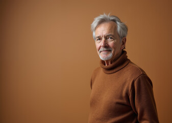 Senior man with thoughtful expression posing against brown background with copy space