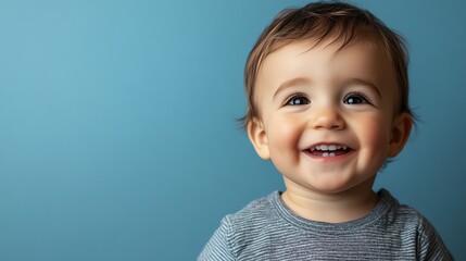 Canvas Print - A baby boy with blond hair laughs as he looks up.