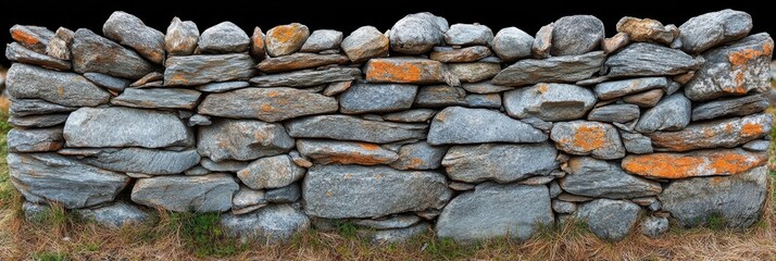 Poster - A weathered stone wall constructed of various sized flat rocks, displaying a natural rustic beauty with a touch of orange lichen