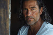 © Fantasy22 - Close-up portrait of a handsome middle-aged hispanic / latino man with long hair, a short salt and pepper beard, and a white t-shirt - dark background, copy space, isolated