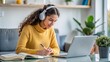 © Htet Wai Phyo - Distance education. Lady teenager in wireless headphones studying  writing on desk at home, side view. Schoolgirl practices for exam assignment