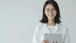 © Dao - Image of young asian woman, company worker in glasses, smiling and holding digital tablet, standing over white background.