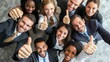 © Johannes - Thumbs up from a happy business team excited about the success they achieve together at work. Overhead view diverse group of corporate people excited by success and give approval to winning