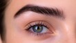 © Plaifah - A close-up of beautifully shaped, thick eyebrows on a woman's face, highlighting the natural arch and clean lines, with soft lighting to enhance facial features.