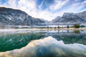 Wall Mural - captivating autumn scene of foggy and sunny morning on almsee lake.