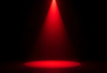 Wall Mural - a single red spotlight shining down onto a black stage, with the focus on a black object in the cent