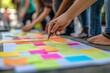 © Leo - Group of diverse people collaborating with colorful sticky notes symbolizing teamwork creativity and community in a collaborative outdoor environment