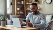 © Felix - Smiling Man Using Laptop and Phone at Home