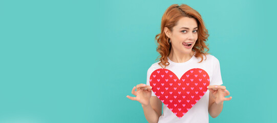 Poster - cheerful redhead lady hold red heart on blue background. Woman isolated face portrait, banner with mock up copyspace.