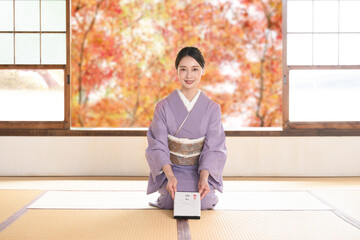 Wall Mural - A woman in kimono sitting in seiza thanking for winter gifts and year-end gifts