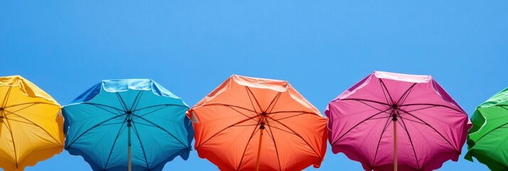 Vibrant beach umbrellas contrasting with a clear summer sky