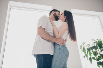 Poster - Photo of cheerful cute young couple enjoy weekend couple hugging kiss buy new apartment indoors inside house home