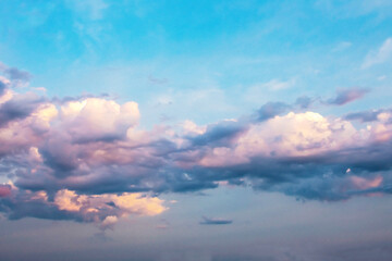 Multi-colored cumulus clouds at sunset in summer.Illustration.