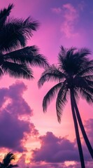 Wall Mural - Palm trees tower against a stunning sunset sky, featuring vibrant shades of purple and pink as the day transitions to night