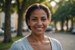 © ThomasLENNE - Close portrait of a smiling 40s Dominican woman looking at the camera, Dominican outdoors blurred background