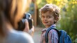 © Morning - A mother takes a photo of her young son outside.