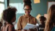 © Morning - Smiling teacher with glasses speaks to her students.