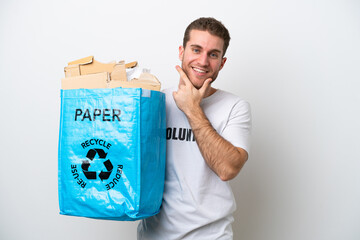 Wall Mural - Young caucasian man holding a recycling bag full of paper to recycle isolated on white background happy and smiling