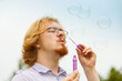 © Voyagerix - Man blowing soap bubbles, having fun