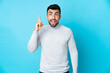 © luismolinero - Caucasian man over isolated blue background intending to realizes the solution while lifting a finger up