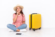 © luismolinero - Young traveler girl sitting one the floor isolated on white background thinking an idea while looking up