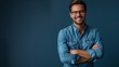 © ifoto - portrait of a handsome smiling man in a blue shirt and glasses with his arms crossed on a dark blue background
