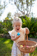 © Austockphoto - Happy toddler doing an easter egg hunt in garden finding chocolate egg