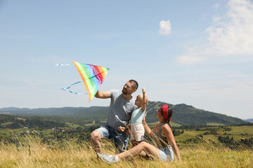 Canvas Print - Happy family flying kite at field under blue sky