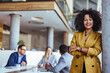 © Dragana Gordic - Confident Businesswoman in Office with Team Meeting in Background