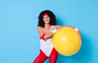 Wall Mural - Aerobics. Happy woman with fitness ball on light blue background