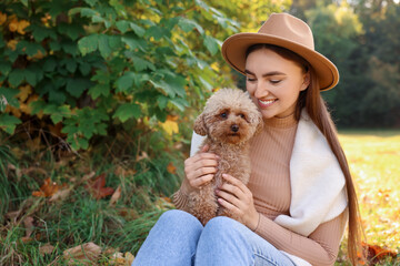 Sticker - Smiling woman with cute dog in autumn park. Space for text