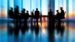 © PRIMPROW - Leadership meeting in progress with blurred office workers discussing growth strategies around a sleek conference table.