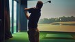 © VK Studio - A man plays golf indoors using a golf simulator, concentrating intently on his swing in a virtual environment.