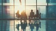 © VK Studio - A group of silhouetted individuals during a meeting in a large, glass-walled boardroom, with the sun setting behind them, creating a reflective atmosphere.