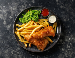 British Fish and chips with mashed peas, tartar and ketchup sauce.