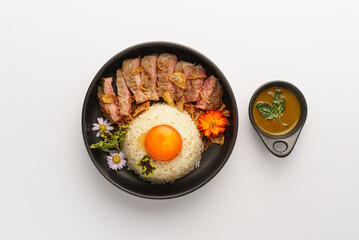 Delicious rice bowl with beef and egg garnish