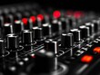 © nitnicha - Close-up view of a modern audio mixing console with various knobs and sliders. The high-tech interface features illuminated controls for sound adjustment.