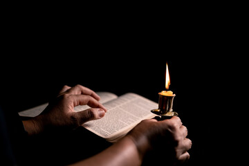 Wall Mural - In the church, candle flickered beside cross as Christians gathered to pray, their faith in Jesus and spiritual devotion illuminated by Bible in background, deepening their Catholic worship.