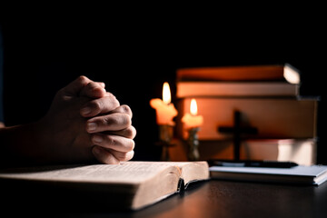 Wall Mural - In the church, candle flickered beside cross as Christians gathered to pray, their faith in Jesus and spiritual devotion illuminated by Bible in background, deepening their Catholic worship.