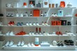 © Graph Squad - A store with a white wall and shelves full of shoes and other items