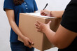 © ArvStd - Asian woman receiving cardboard box parcel from courier woman in blue uniform cap. Isolated on white background.Sign document customer