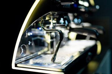 Steaming milk in a modern café. A sleek coffee machine is actively steaming milk, showcasing its shiny metal design and bright blue lights in a contemporary café.