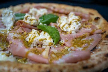 Close-up of Pizza Mortadella from the side, featuring delicate mortadella slices and a crisp, golden crust. It is ideal for food photography, restaurant advertising, or gourmet blogs.