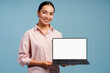 © Maria Vitkovska - Beautiful Asian woman smiling holding laptop with blank screen for advertisement, mockup, copy space